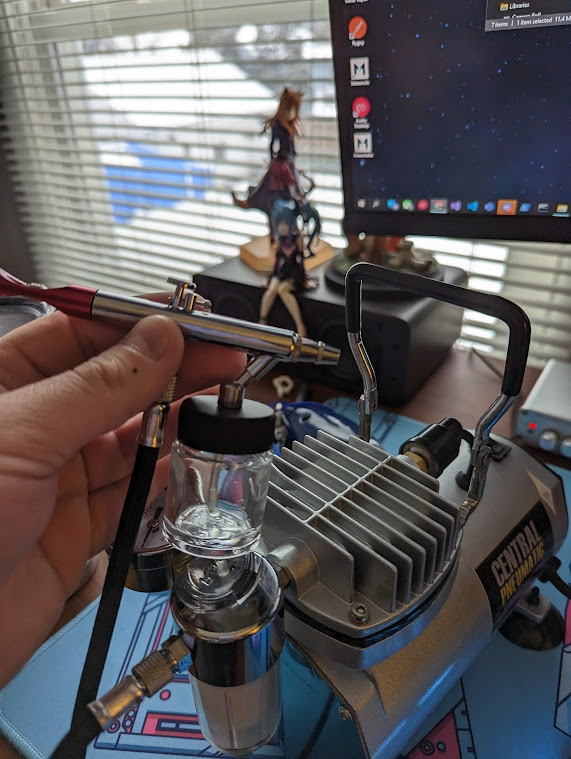 Photo of an airbrush and airbrush compressor on my desk